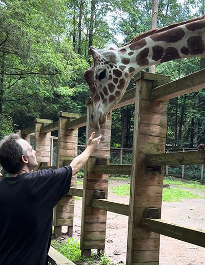 Joe petting a giraffe